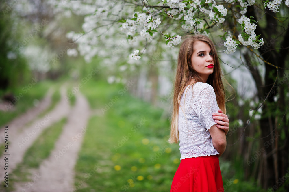 Portrait of beautiful girl with red lips at spring blossom garden, wear on red dress and white blouse. Portrait of beautiful girl with red lips at spring blossom garden, wear on red dress and white blouse.