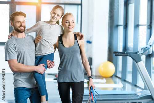 Portrait of happy family standing together at fitness center