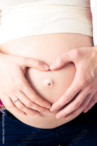 Wallpaper Mural A pregnant woman touches her naked stomach, showing her hands a heart shape around the navel Torontodigital.ca