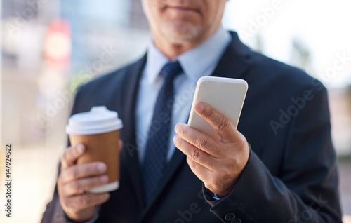senior businessman with smartphone and coffee