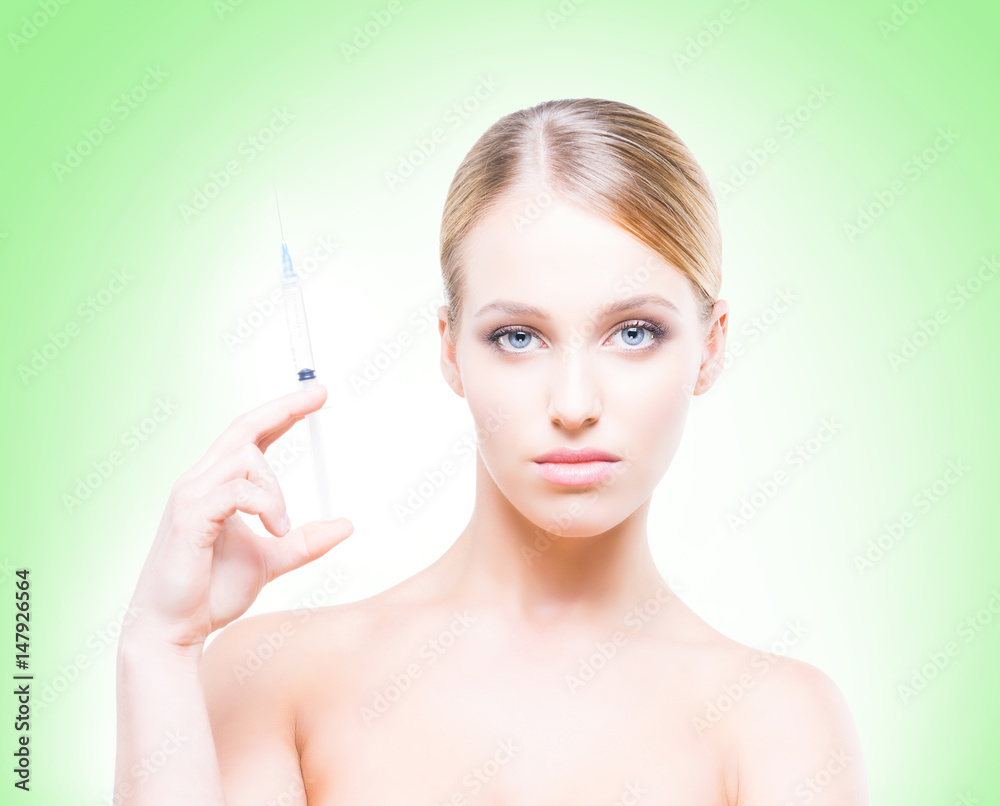 Young, beautiful and healthy woman having skin injections over green background. Plastic surgery concept.