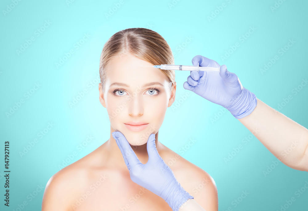 Doctor injecting in a beautiful face of a young woman. Plastic surgery concept. Doctor injecting in a beautiful face of a young woman. Plastic surgery concept.