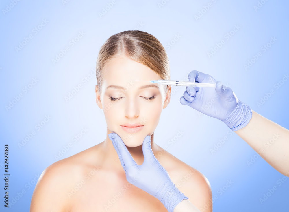 Doctor injecting in a beautiful face of a young woman. Plastic surgery concept. Doctor injecting in a beautiful face of a young woman. Plastic surgery concept.