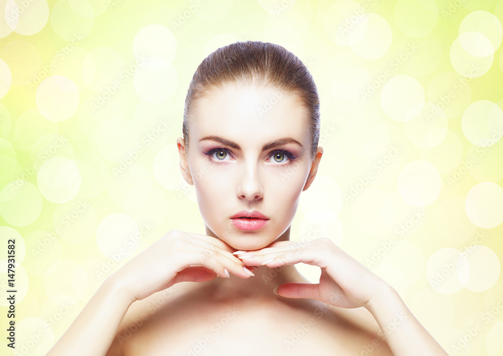 Naklejka premium Portrait of young, beautiful and healthy woman: over yellow background. Healthcare, spa, makeup and face lifting concept.