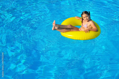 Adorable toddler relaxing in swimming pool