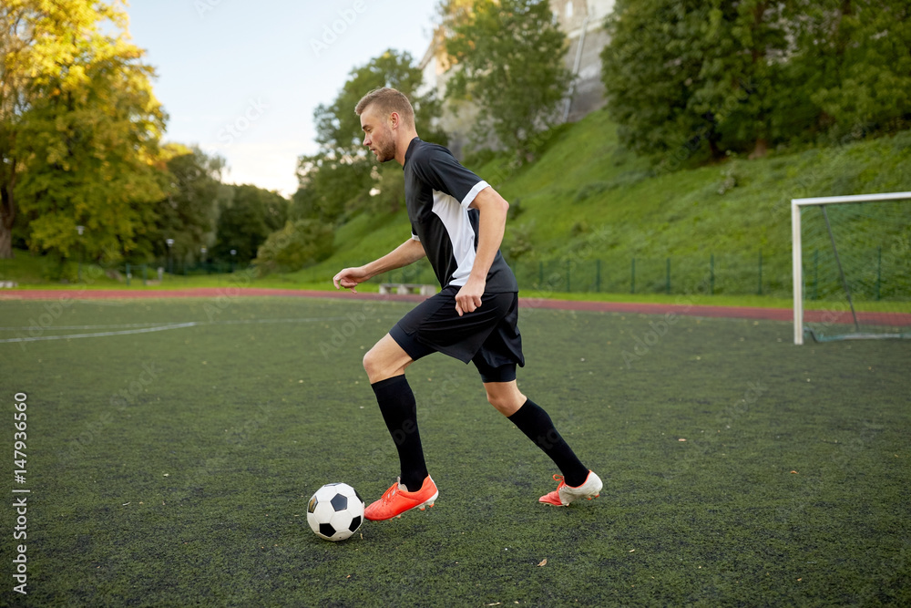 soccer player playing with ball on football field soccer player playing with ball on football field