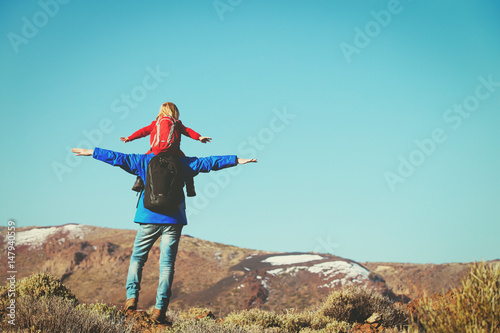 father with little daughter hiking in mountains