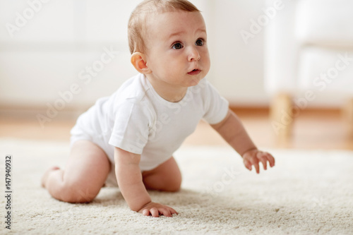 little baby in diaper crawling on floor at home