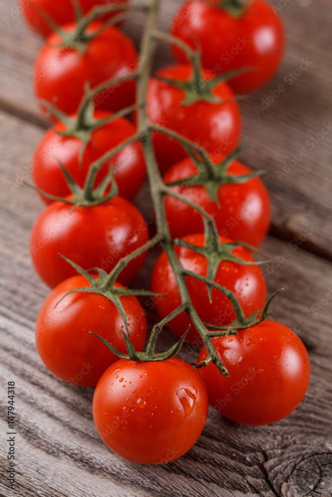 Fresh, ripe cherry tomatoes on an old wooden background