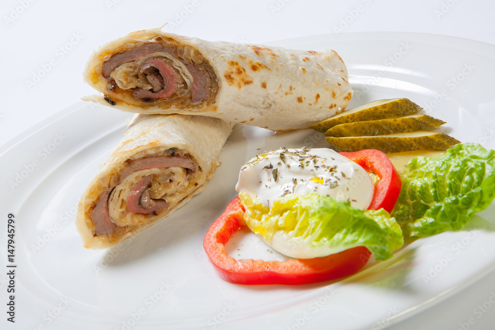 Rolls from pita bread stuffed with beef and onion decorated with vegetables Rolls from pita bread stuffed with beef and onion decorated with vegetables