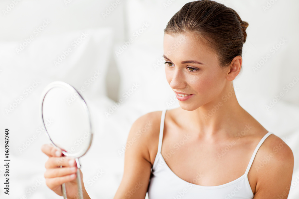 beautiful woman with mirror sitting on bed at home beautiful woman with mirror sitting on bed at home
