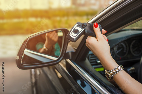 female hand holding Car keys from the car window