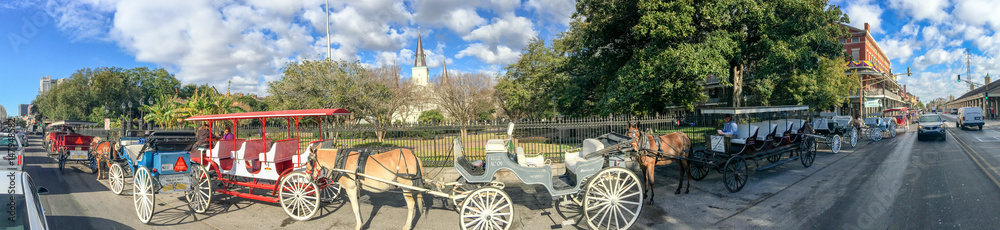 NEW ORLEANS - FEBRUARY 2016: Panoramic view of Horse Carriages along Jackson Square. New Orleans attracts 15 million people annually NEW ORLEANS - FEBRUARY 2016: Panoramic view of Horse Carriages along Jackson Square. New Orleans attracts 15 million people annually