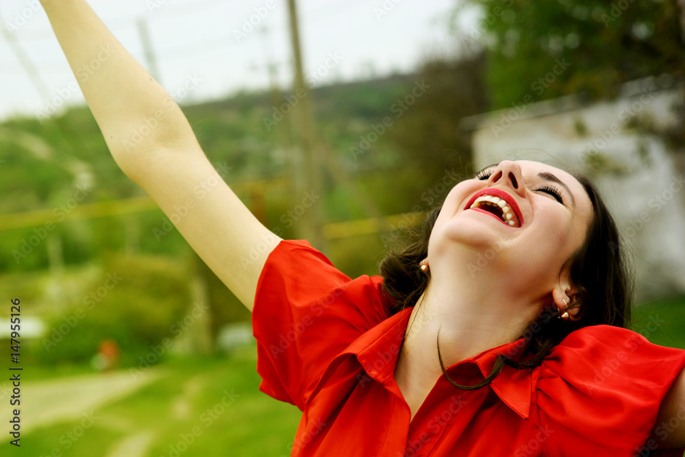 Happy girl in red dress looks up at the sky Happy girl in red dress looks up at the sky