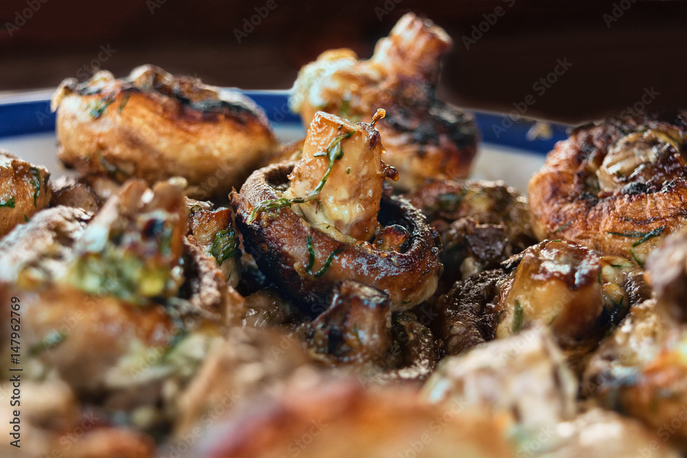 Whole mushrooms roasted on a grill with spices of golden color. Whole mushrooms roasted on a grill with spices of golden color.