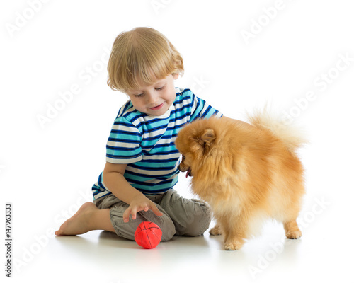 Little boy playing with dog...
