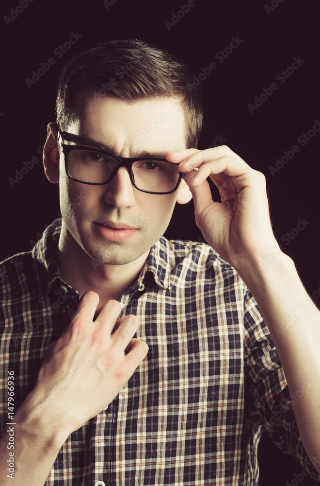 young guy, nerd in glasses and fashionable checkered shirt