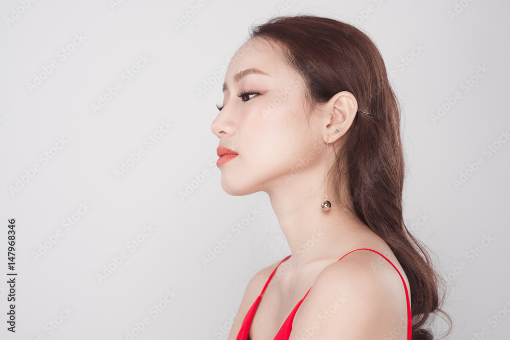 Portrait of stylish asian woman wearing red dress on grey background. Portrait of stylish asian woman wearing red dress on grey background.