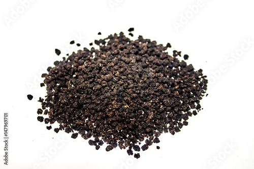 Black granulated dry tea on white