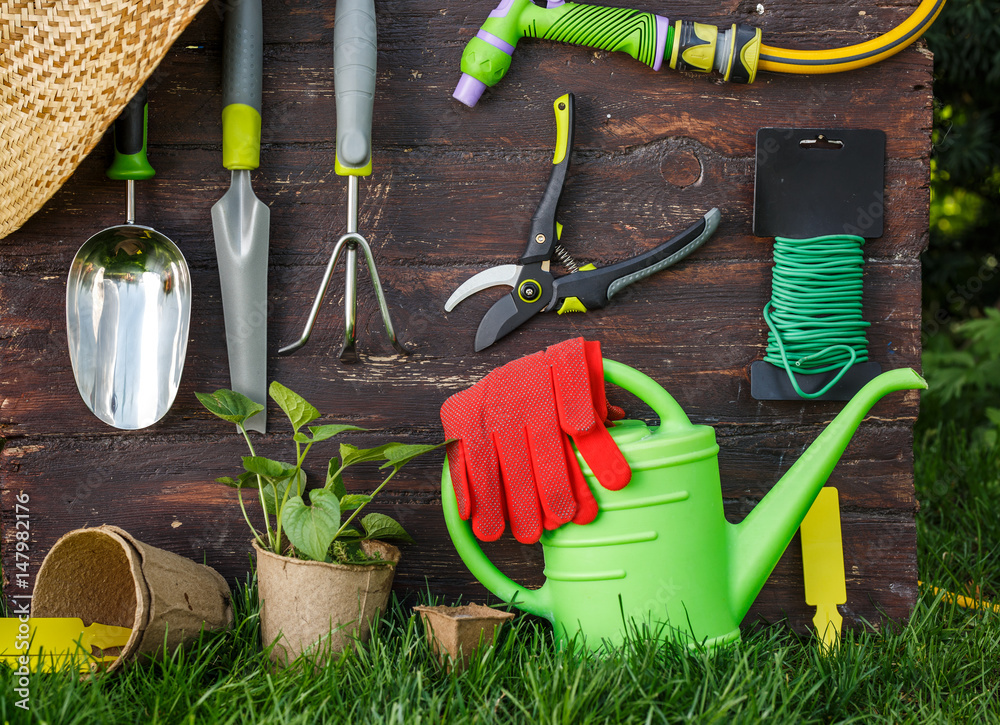 Gardening tools and a straw hat on the grass in the garden. Gardening tools and a straw hat on the grass in the garden.