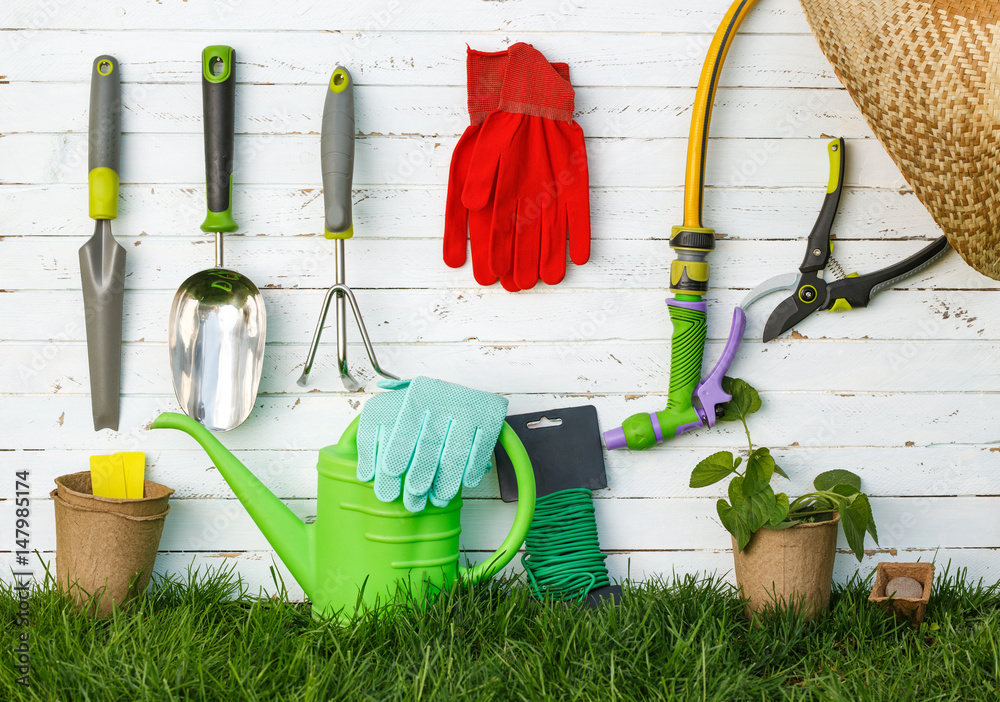 Gardening tools and a straw hat on the grass in the garden. Gardening tools and a straw hat on the grass in the garden.