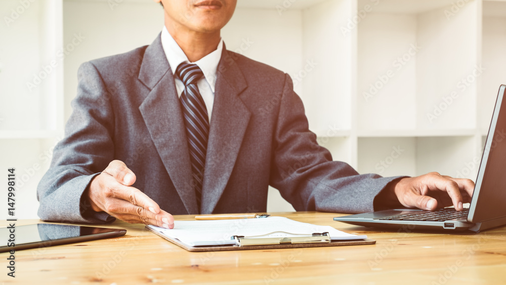 unrecognizable people wearing suits working at a wooden office desk unrecognizable people wearing suits working at a wooden office desk