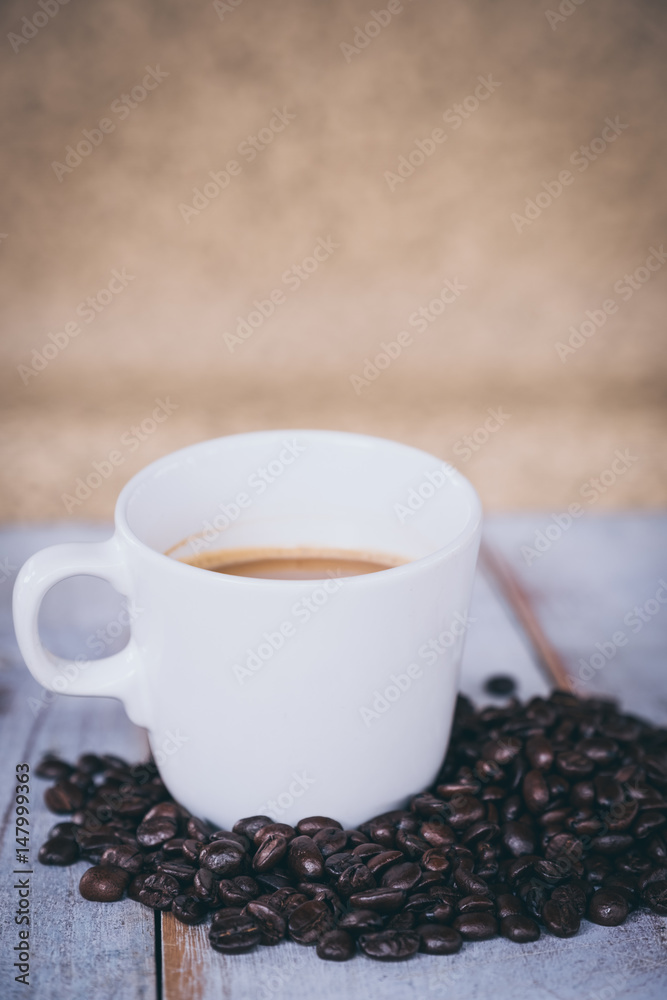 Fototapeta premium cup of coffee on old wooden desk. Simple workspace or coffee break in morning/ selective focus
