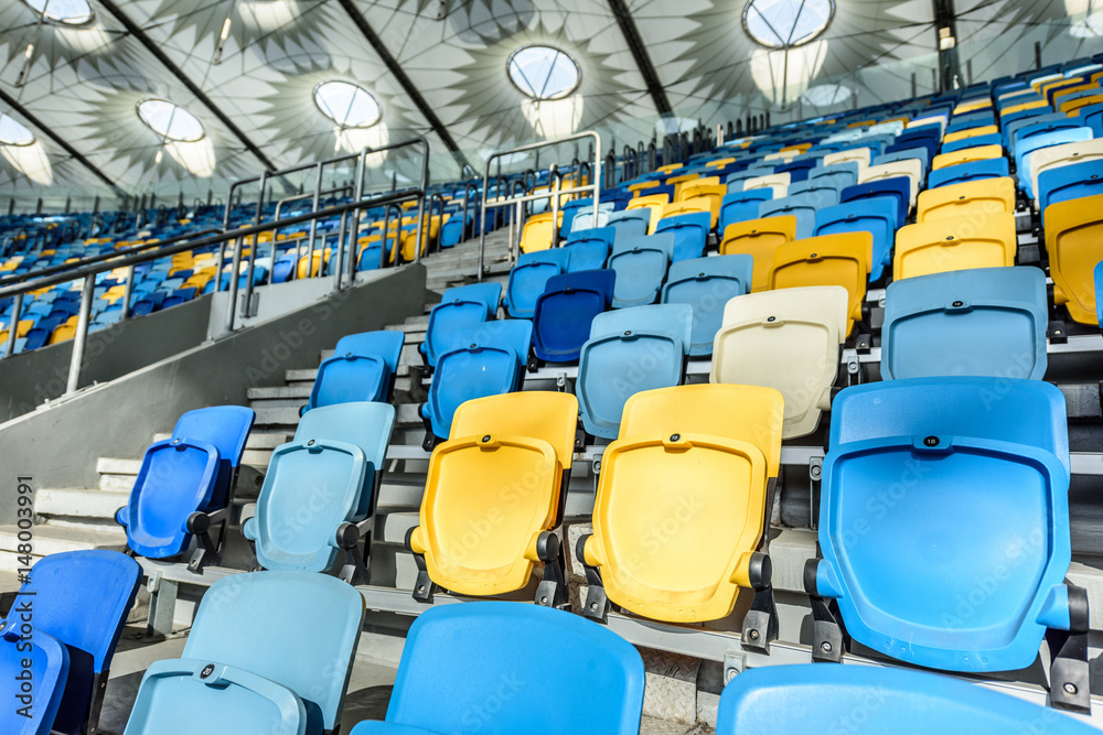 Obraz premium rows of yellow and blue stadium seats and stadium stairs