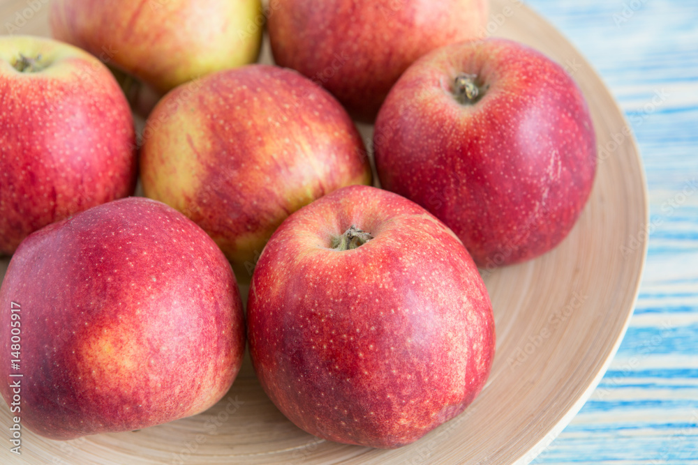 Beautiful red apples in a wooden plate Beautiful red apples in a wooden plate