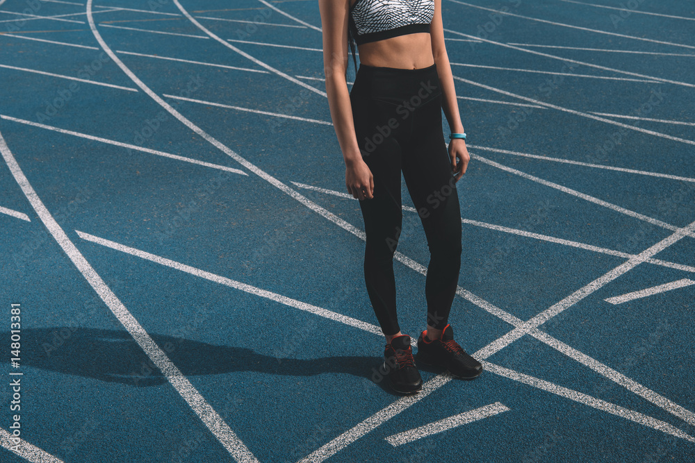 young sportswoman standing on running track stadium, running woman tired concept