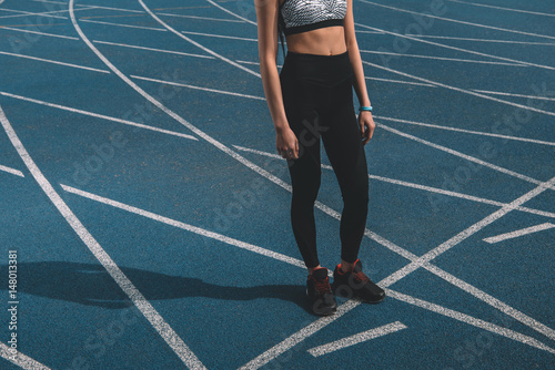 young sportswoman standing on running track stadium  running woman tired concept