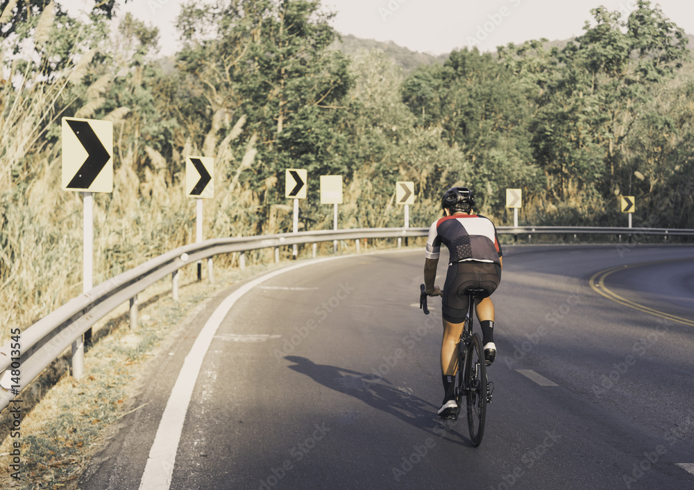 Asian men are cycling road bike morning uphill on the road Asian men are cycling road bike morning uphill on the road