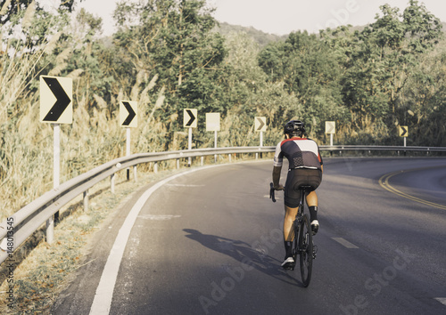 Asian men are cycling road bike morning uphill on the road