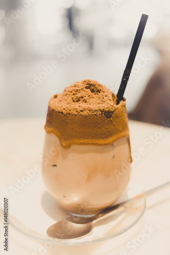 iced chocolate and coffee with chocolate malt powder on the top of smoothie glass as a special menu at the coffee shop, selective focus. vintage photo and film style.