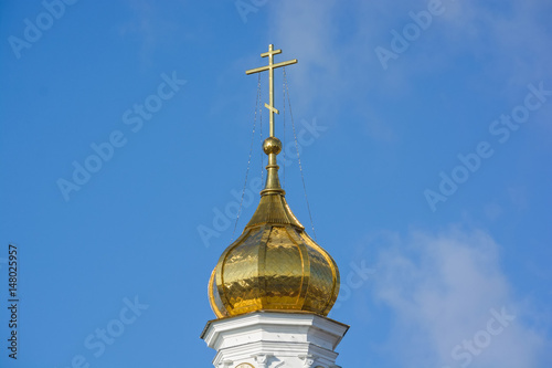 Orthodox cross at church rooftop against blue sky photo