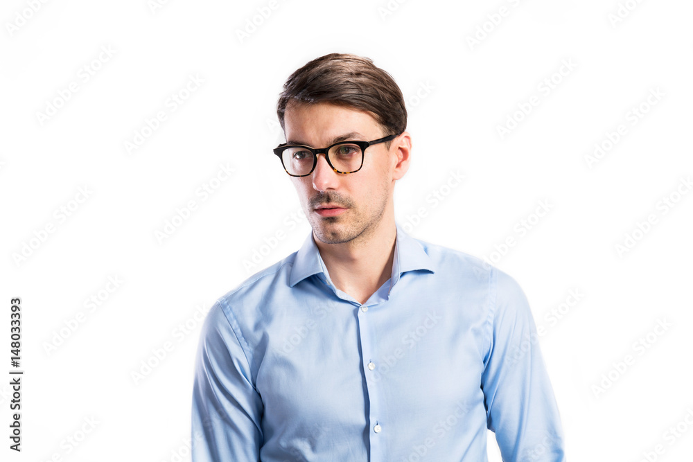 Handsome young man in blue shirt. Studio shot, isolated.