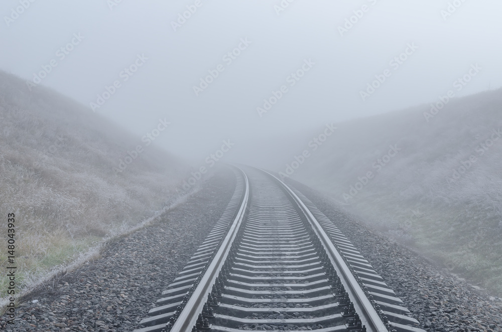 railway goes to horizon in fog