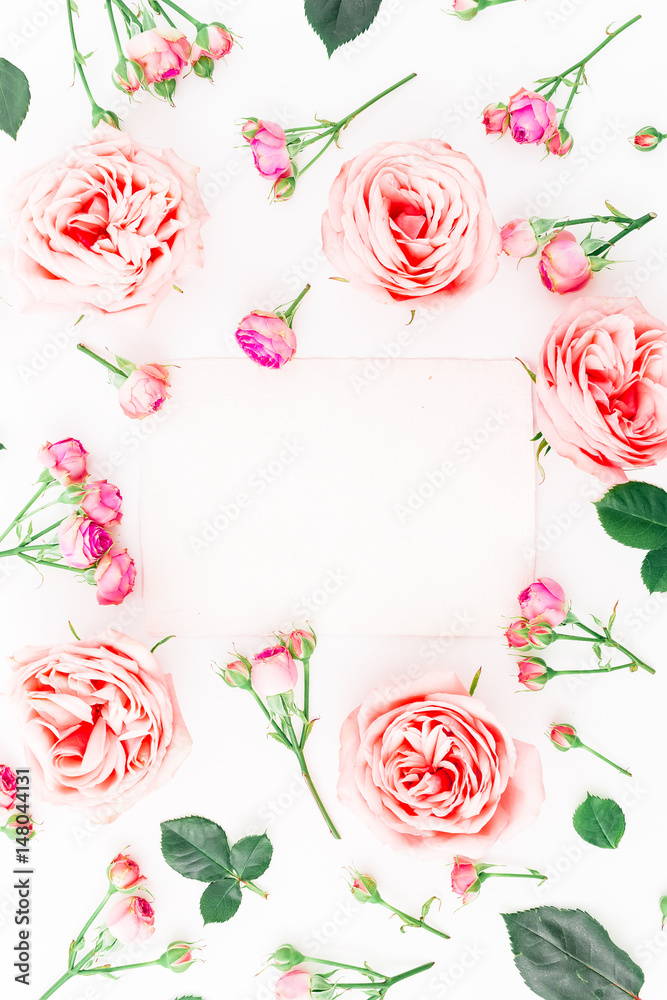 Floral frame made of pink roses, buds and leaves on white background. Flat lay, top view. Floral pattern.