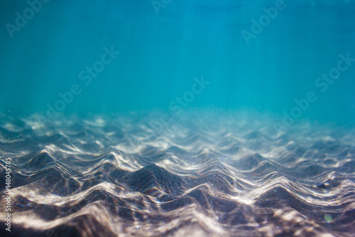 Carta da parati Pattern of sand in underwater. Blue water in ocean