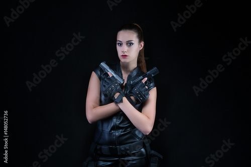 Superhero police woman in a leather catsuit with guns