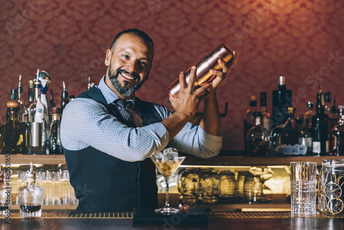 Barman is making cocktail at night club. photo