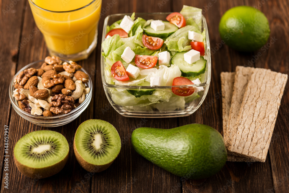 Fresh salad and fruits on wooden background. Fitness breakfast. Healthy eating, dieting, slimming and weigh loss concept. Fresh salad and fruits on wooden background. Fitness breakfast. Healthy eating, dieting, slimming and weigh loss concept.