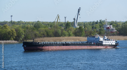 Cargo ship goes along the river water area