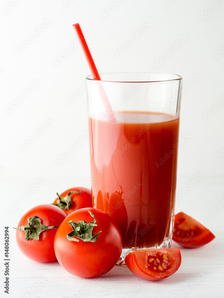 Tomato juice in glass and fresh tomatoes on white wooden table. Tomato juice in glass and fresh tomatoes on white wooden table.