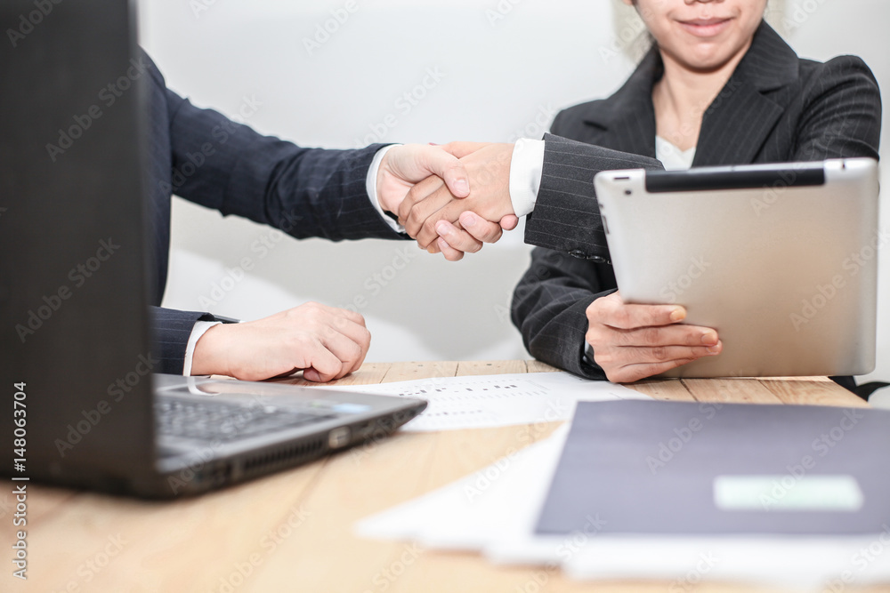 confident business man shaking hands during a meeting to aim dealing success and partner concept in the office . confident business man shaking hands during a meeting to aim dealing success and partner concept in the office .