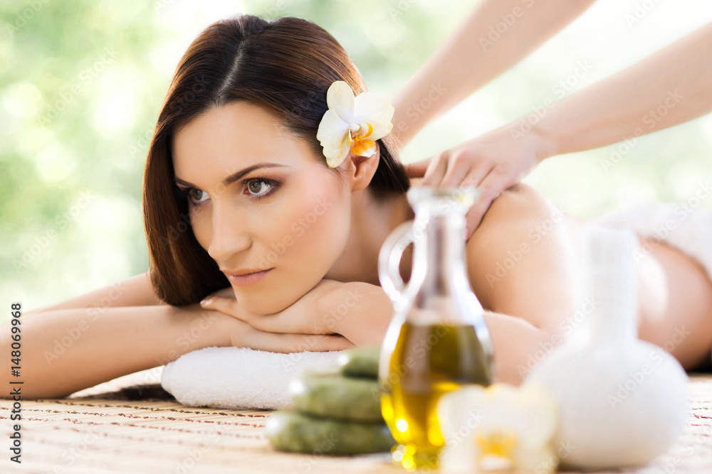 Beautiful, young and healthy woman in spa salon. Massage treatment over green summer or spring background. Traditional medicine and healing concept. Beautiful, young and healthy woman in spa salon. Massage treatment over green summer or spring background. Traditional medicine and healing concept.