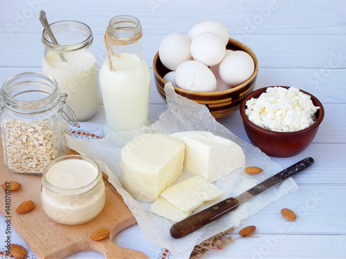 Set of fresh dairy products on wooden background: milk, cheese cottage, yogurt egg, mozzarella ryazhenka, feta.