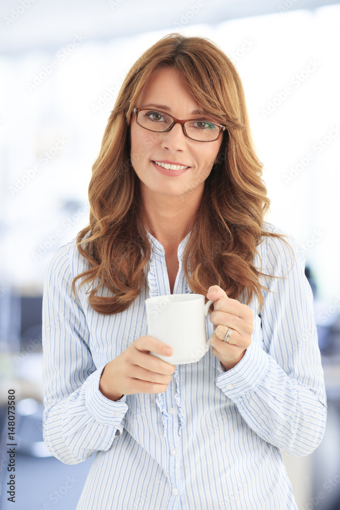 Attractive mature professional woman. Shot of a smiling businesswoman drinking a hot beverage at office. Attractive mature professional woman. Shot of a smiling businesswoman drinking a hot beverage at office.