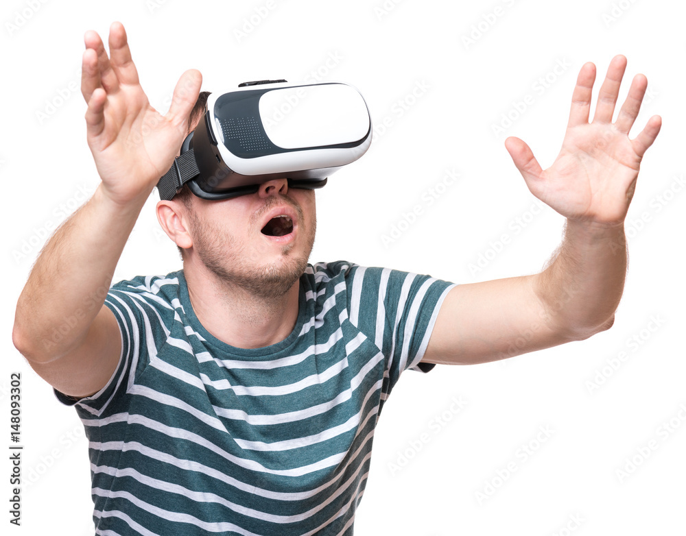 Naklejka premium Amazed man wearing virtual reality goggles watching movies or playing video games gesticulating hands, isolated on white background. Surprised male looking in VR glasses.