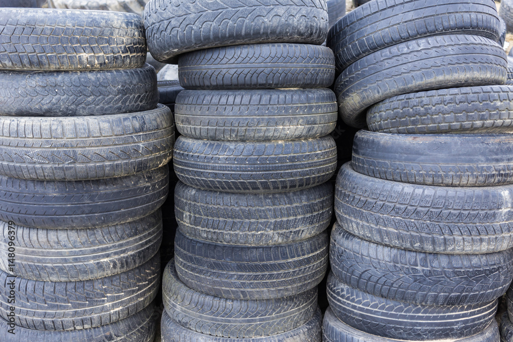 Old rubber tires from the tractor and the car folded like towers. Dairy farm in Podlasie, Poland. Old rubber tires from the tractor and the car folded like towers. Dairy farm in Podlasie, Poland.